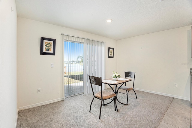 dining area with light tile patterned floors and a water view