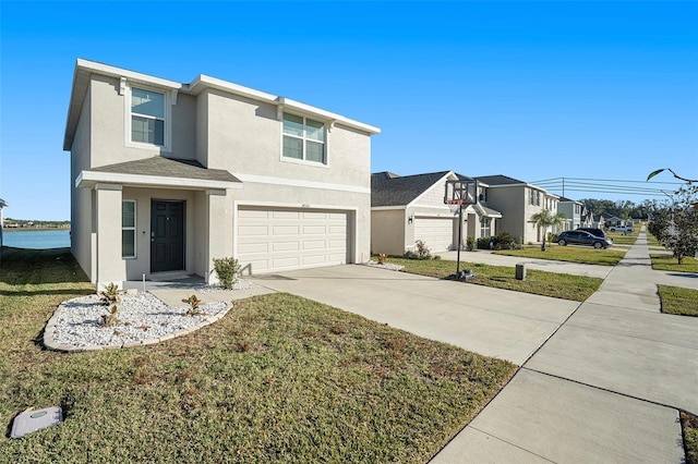 view of front of home featuring a front lawn, a garage, and a water view