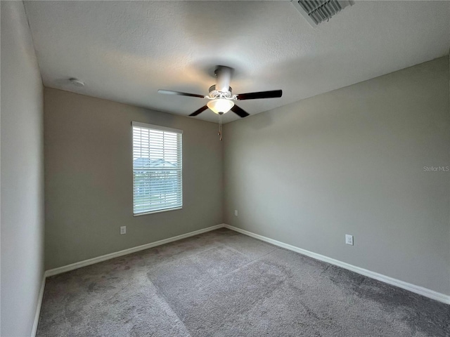 carpeted spare room featuring ceiling fan and a textured ceiling