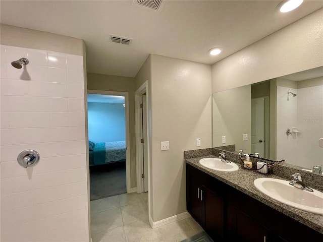 bathroom featuring tile patterned flooring, vanity, and a shower