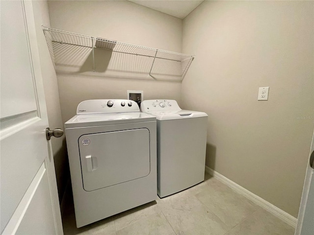 laundry area featuring washing machine and dryer and light tile patterned floors