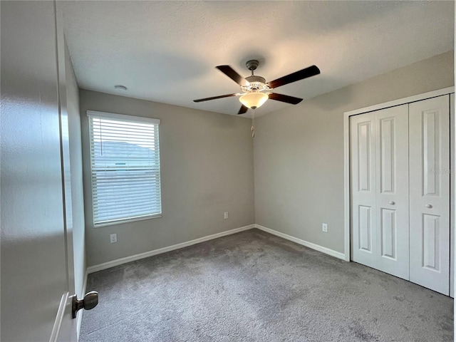 unfurnished bedroom featuring carpet flooring, a textured ceiling, ceiling fan, and a closet