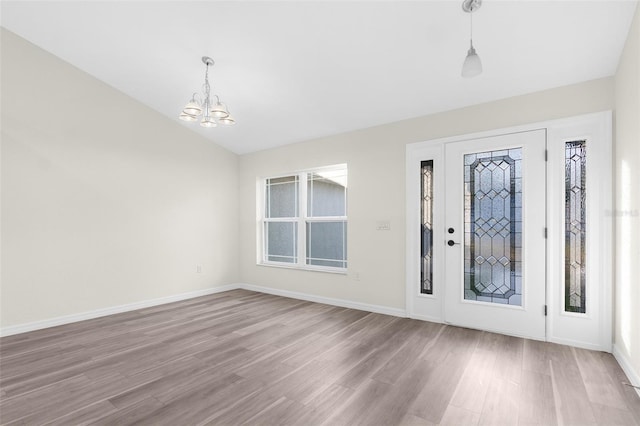 entrance foyer with light hardwood / wood-style floors and a notable chandelier