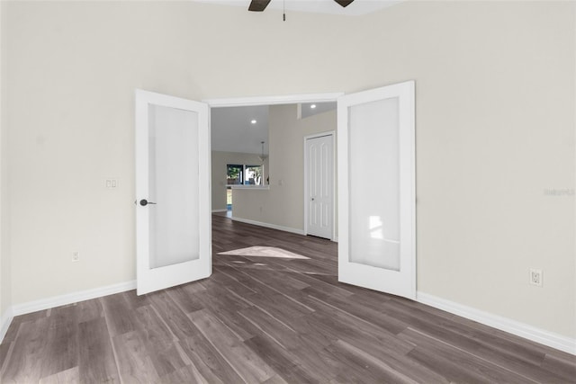 unfurnished room with french doors, ceiling fan, and dark wood-type flooring