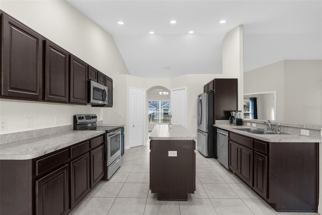 kitchen featuring sink, a center island, light tile patterned flooring, and appliances with stainless steel finishes