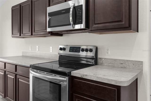 kitchen featuring appliances with stainless steel finishes and dark brown cabinets