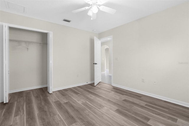 unfurnished bedroom with a closet, ceiling fan, and hardwood / wood-style floors