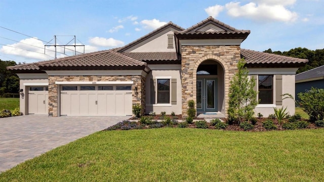 mediterranean / spanish-style home with a garage, a front yard, and french doors