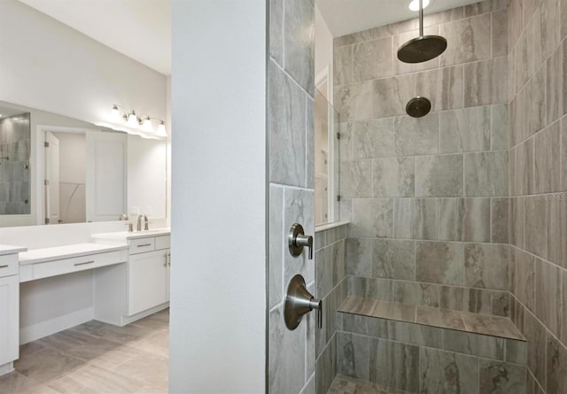 bathroom featuring vanity and tiled shower