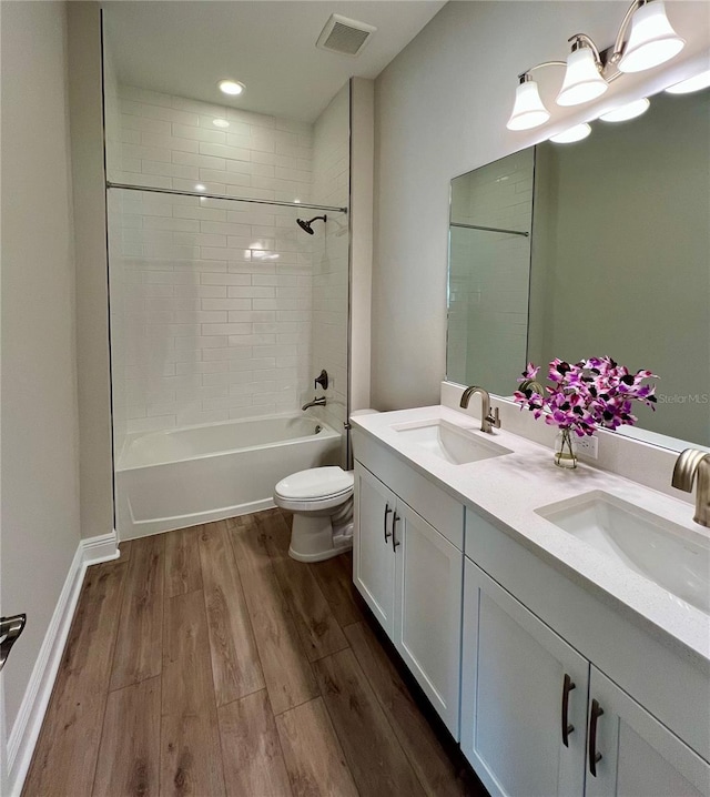 full bathroom with vanity, toilet, tiled shower / bath combo, and wood-type flooring