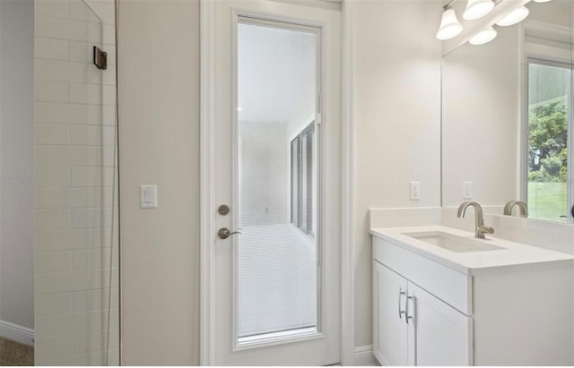 bathroom featuring tiled shower and vanity