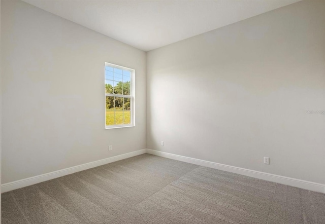 carpeted spare room featuring baseboards