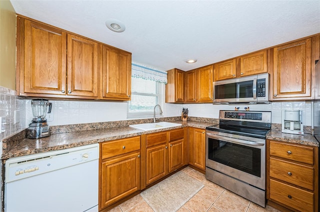 kitchen featuring sink, light tile patterned floors, and stainless steel appliances