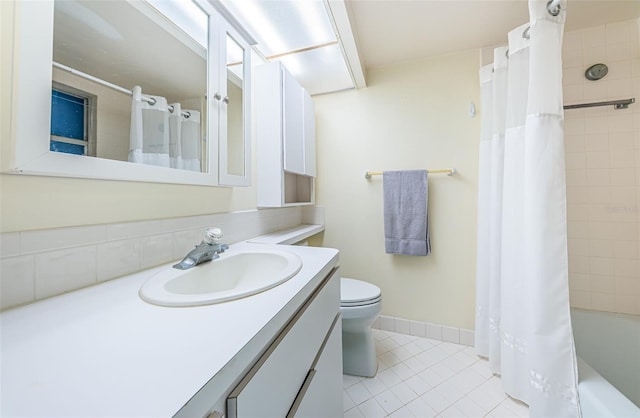 full bathroom featuring tile patterned floors, shower / tub combo with curtain, vanity, and toilet