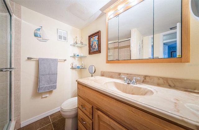 bathroom featuring toilet, vanity, tile patterned floors, and walk in shower