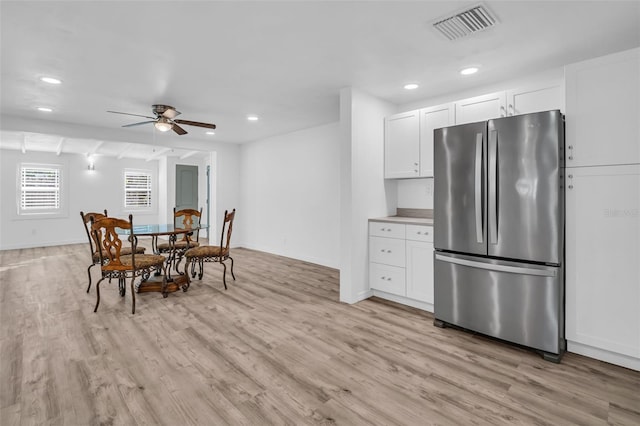 kitchen featuring ceiling fan, light wood-type flooring, white cabinets, and stainless steel refrigerator