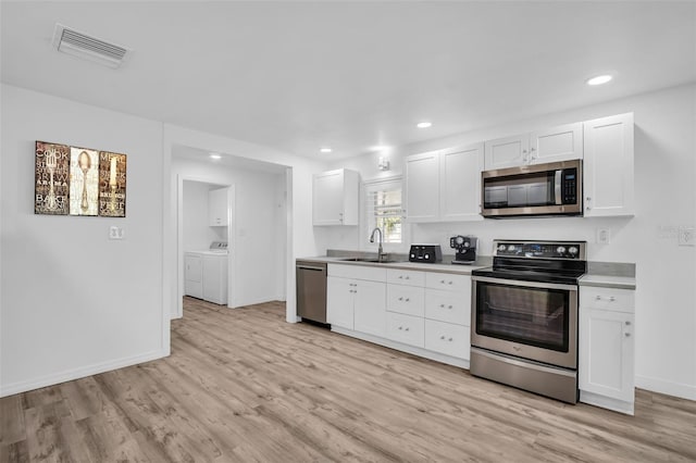 kitchen with sink, stainless steel appliances, light hardwood / wood-style floors, white cabinets, and separate washer and dryer