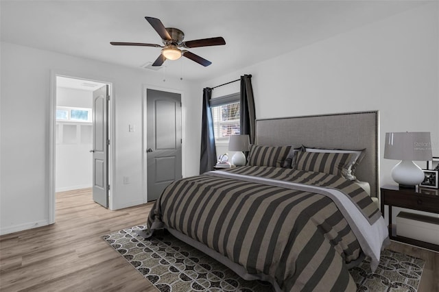 bedroom featuring multiple windows, ceiling fan, and light wood-type flooring