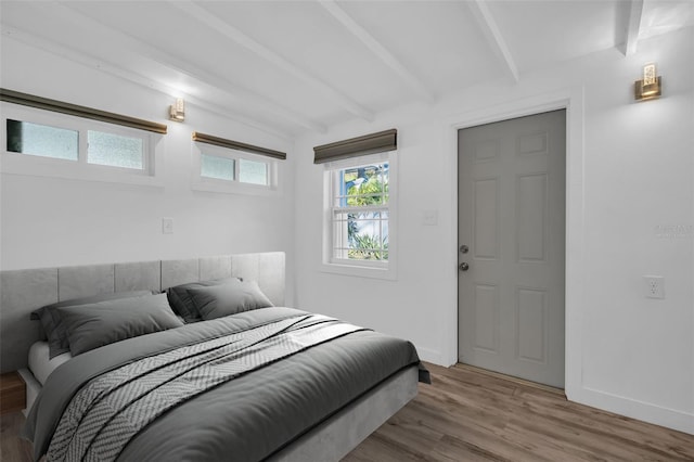 bedroom with hardwood / wood-style flooring and lofted ceiling with beams