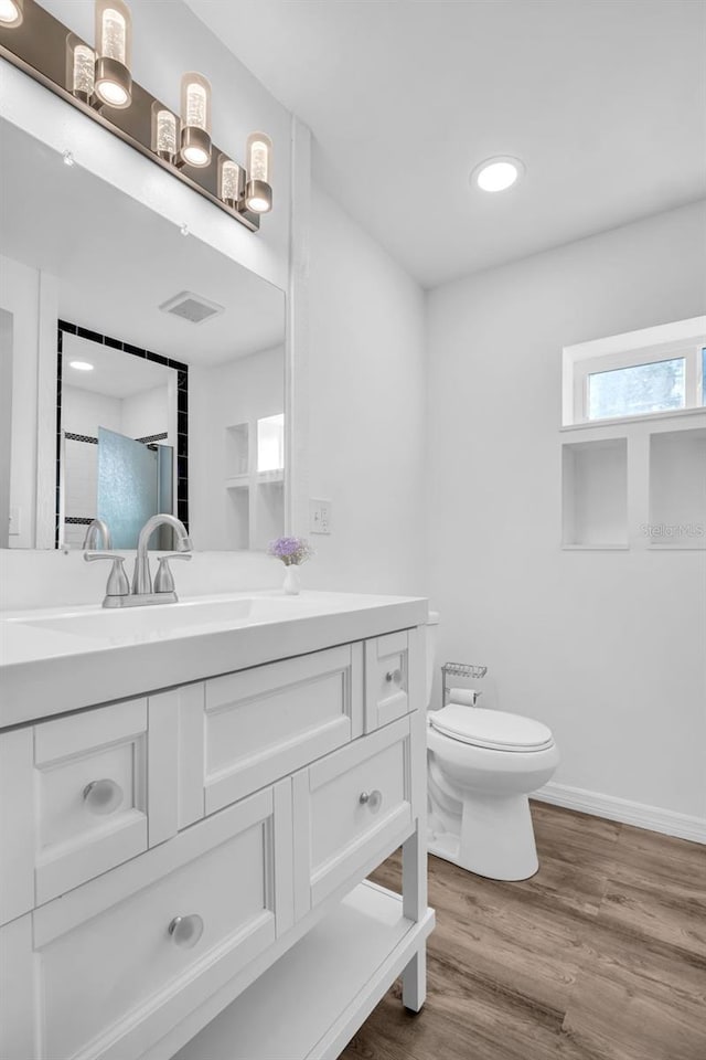 bathroom with vanity, toilet, and wood-type flooring