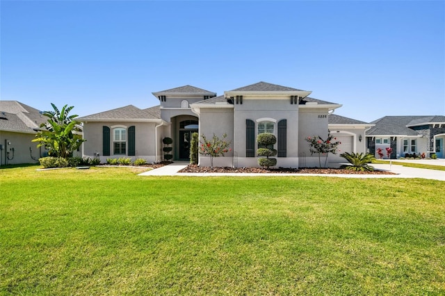 view of front facade featuring a front yard, a garage, driveway, and stucco siding