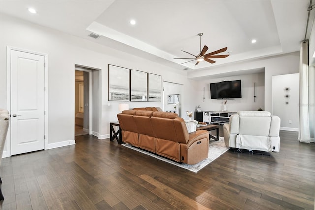 5226 Lake Venice Dr, Wimauma, FL 33598 - living room with visible vents, dark wood-type flooring, a ceiling fan, a tray ceiling, and baseboards