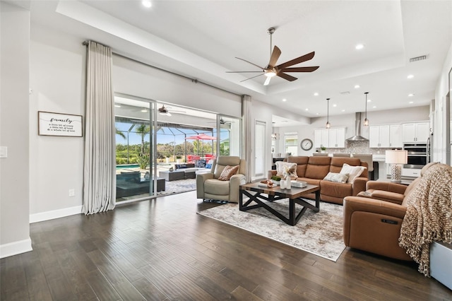 5226 Lake Venice Dr, Wimauma, FL 33598 - living room with a tray ceiling, visible vents, a sunroom, and dark wood-type flooring