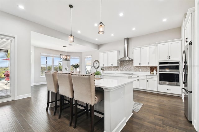 5226 Lake Venice Dr, Wimauma, FL 33598 - kitchen featuring backsplash, white cabinets, stainless steel appliances, wall chimney exhaust hood, and dark wood-style flooring