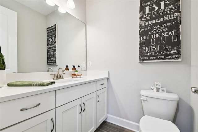 5226 Lake Venice Dr, Wimauma, FL 33598 - bathroom with toilet, vanity, baseboards, and wood finished floors