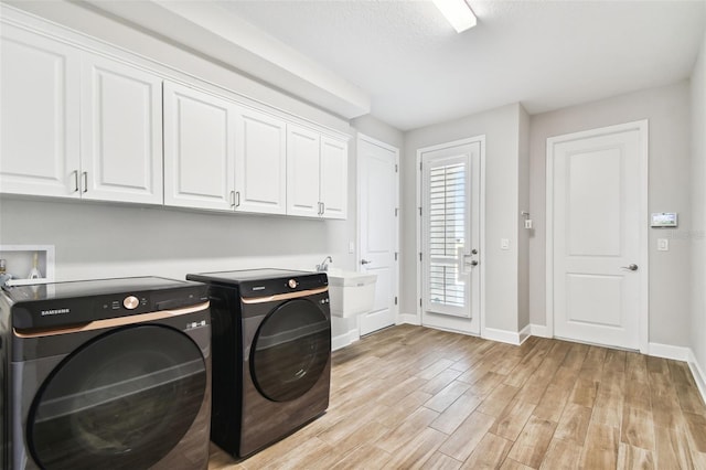 5226 Lake Venice Dr, Wimauma, FL 33598 - laundry room featuring baseboards, light wood finished floors, washing machine and clothes dryer, cabinet space, and a sink