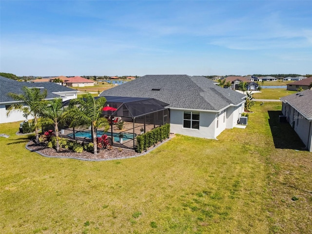 5226 Lake Venice Dr, Wimauma, FL 33598 - back of house featuring glass enclosure, a yard, an outdoor pool, a shingled roof, and stucco siding