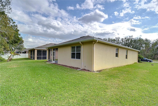 view of property exterior featuring a sunroom and a yard