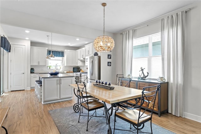 dining space with light hardwood / wood-style flooring and sink