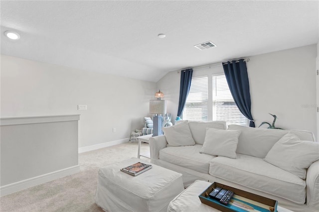 carpeted living room with a textured ceiling and lofted ceiling