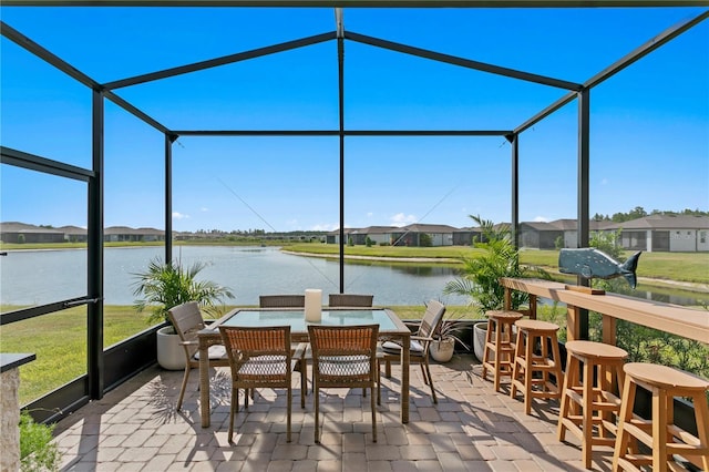 sunroom / solarium featuring a water view