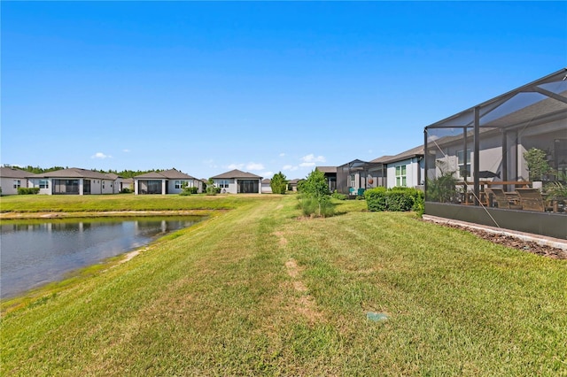 view of yard featuring glass enclosure and a water view