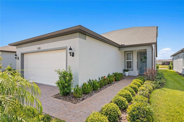 ranch-style home with a garage and a front lawn