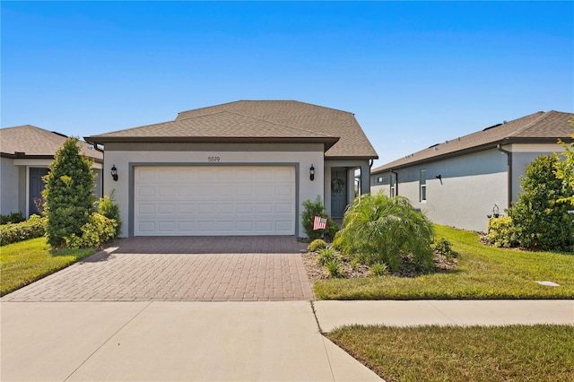 view of front of property with a garage and a front lawn