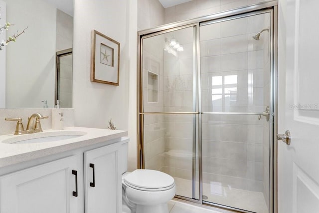 bathroom with vanity, an enclosed shower, and toilet