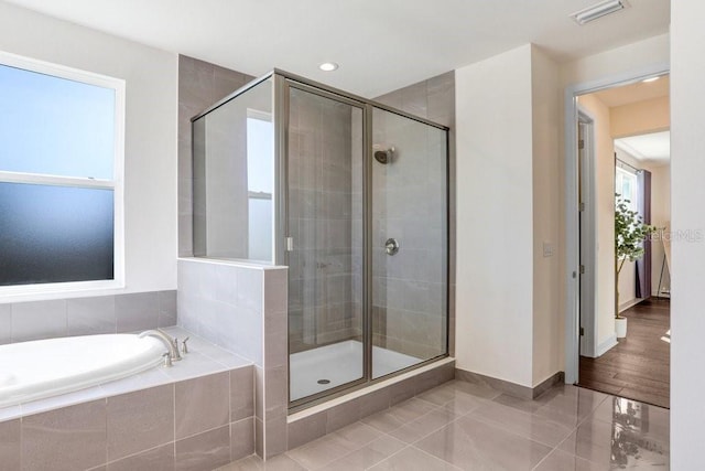 bathroom featuring tile patterned flooring and shower with separate bathtub