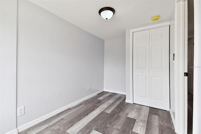 unfurnished bedroom with hardwood / wood-style flooring and a closet