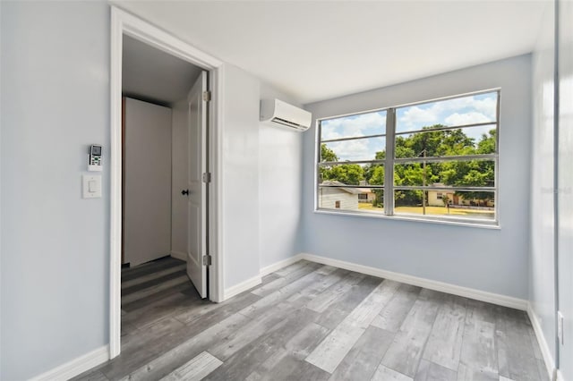 empty room featuring hardwood / wood-style floors and an AC wall unit