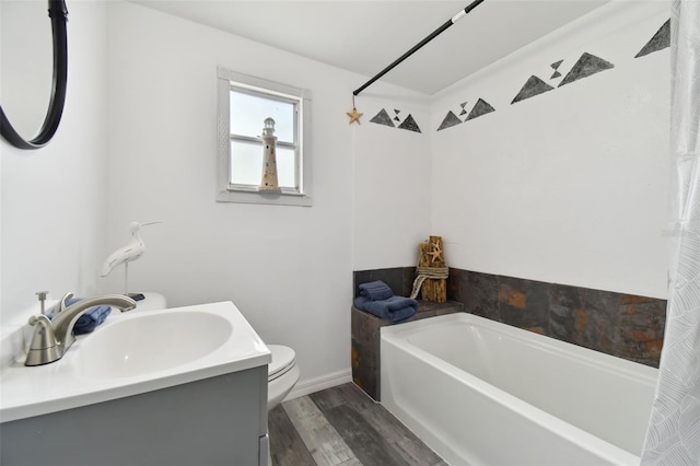 bathroom with hardwood / wood-style floors, toilet, a bathing tub, and vanity