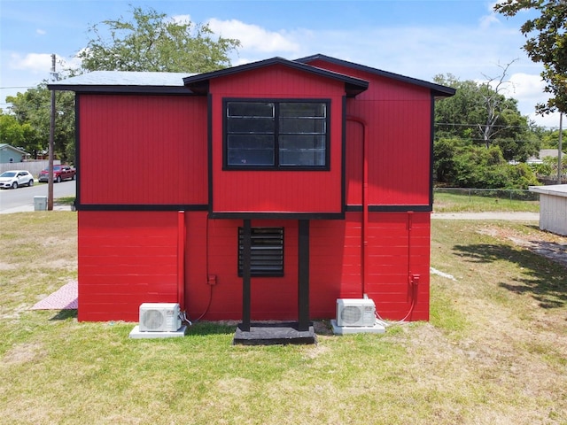 view of outdoor structure featuring ac unit and a lawn