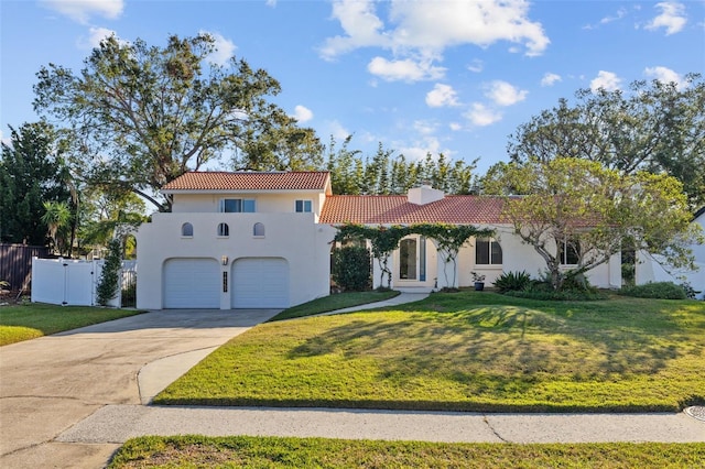 mediterranean / spanish-style home featuring a garage and a front yard