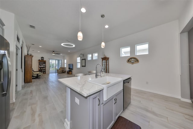 kitchen featuring pendant lighting, a center island with sink, sink, ceiling fan, and appliances with stainless steel finishes