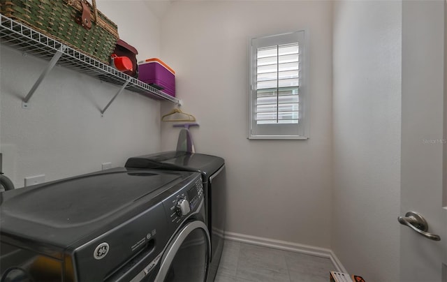 washroom with light tile patterned floors and washing machine and clothes dryer