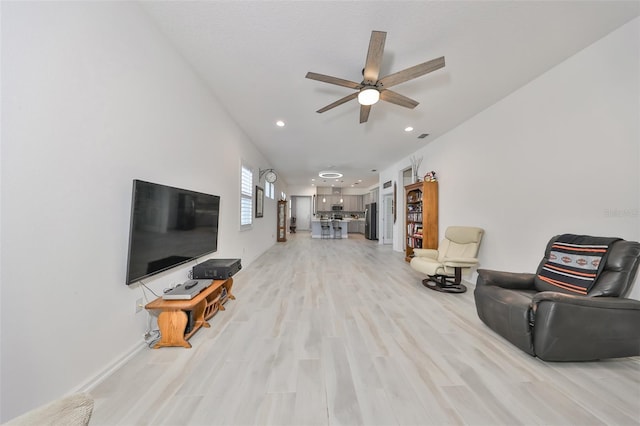 living room featuring light hardwood / wood-style flooring and ceiling fan