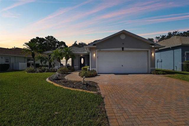 ranch-style home featuring a yard and a garage