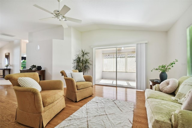 living room with light hardwood / wood-style floors, ceiling fan, and vaulted ceiling